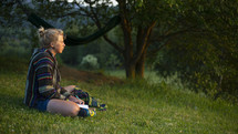 a woman sitting on a grassy hill 