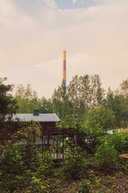 colorful smoke stack in the distance and backyard of a cabin 
