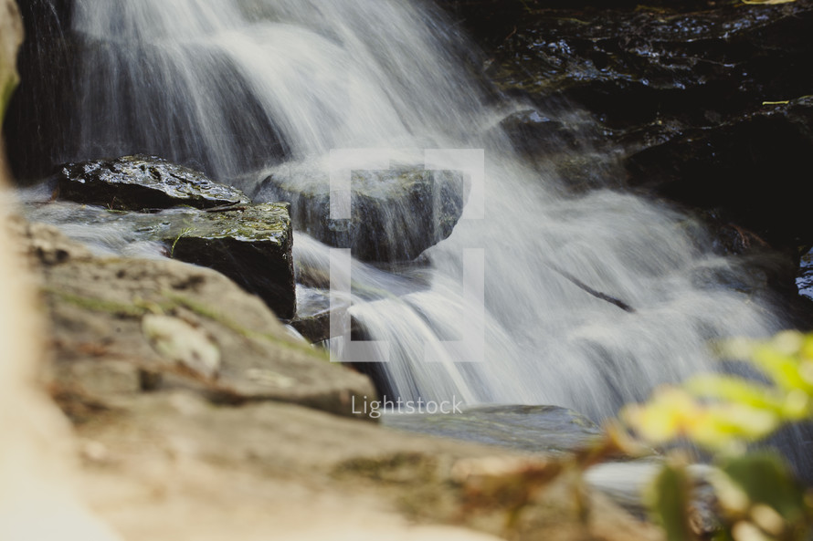 Waterfall in rock-lined stream.