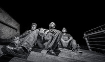 young men sitting on steps at night 