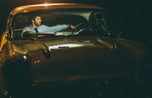 Man sitting in a vintage car.