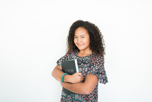 teen girl holding a Bible to her chest 