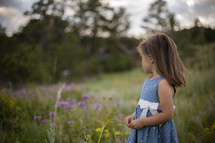 a young girl walking through a meadow 