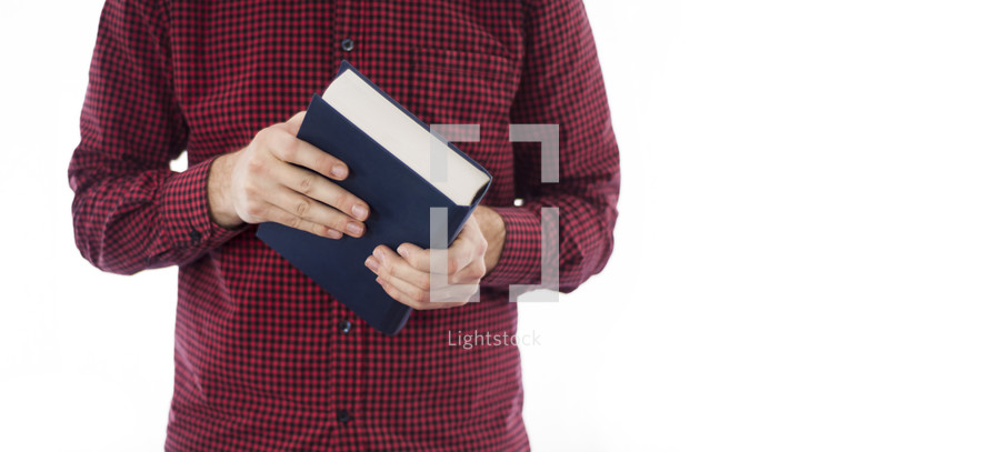 torso of a man holding a Bible 