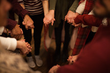 holding hands in a prayer circle at a Christmas party 