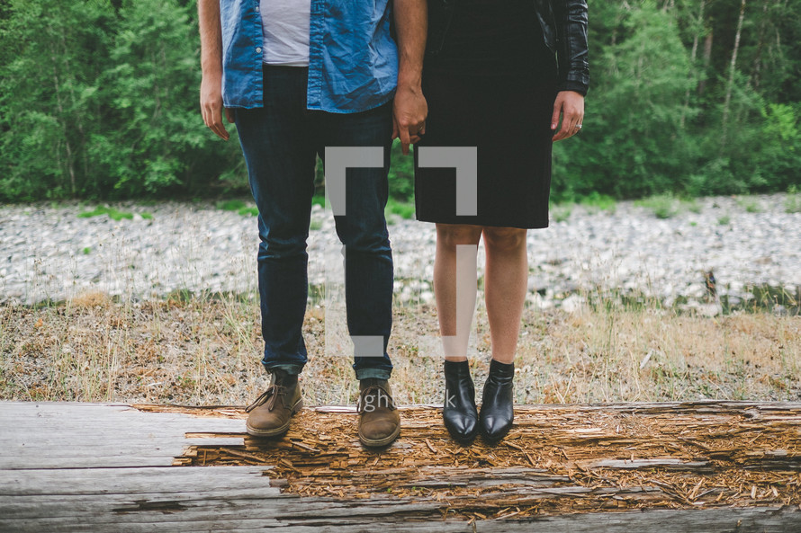 Man and woman standing on a log.