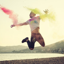 young man jumping with energy and colored powder.