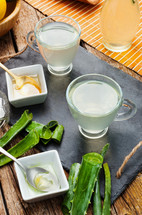 Drink aloe vera and honey. Glass cups on a slate tray.