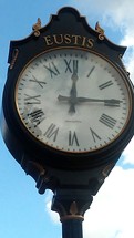 A large clock stands as a landmark in the center of historic downtown Eustis, Florida as a meeting place and landmark in the community. 