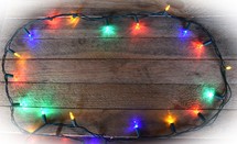 Border of Christmas Lights on wooden background (White Vignette)