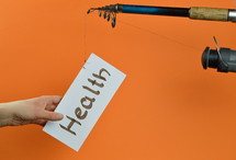 A fishing pole with a piece of paper with the word health on it 