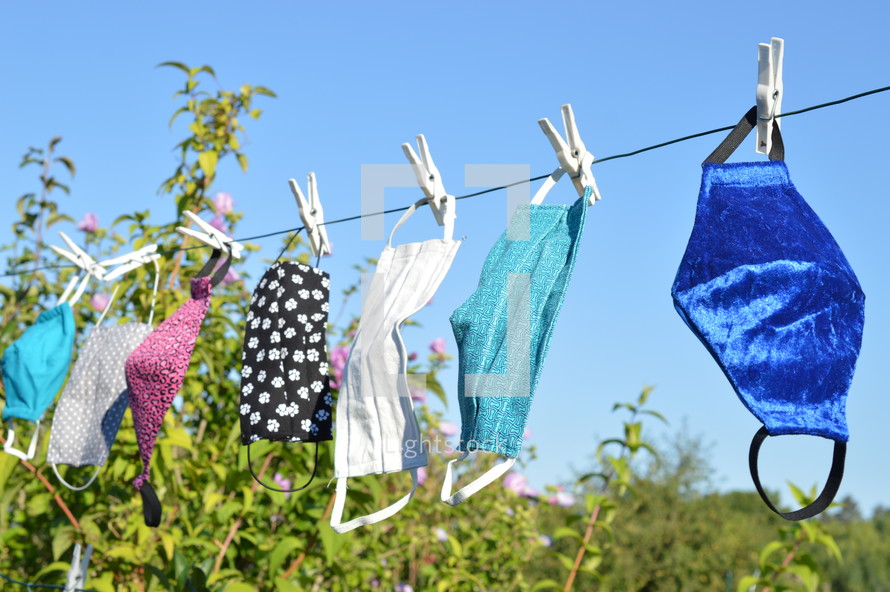 cloth face masks hanging on a clothesline drying 