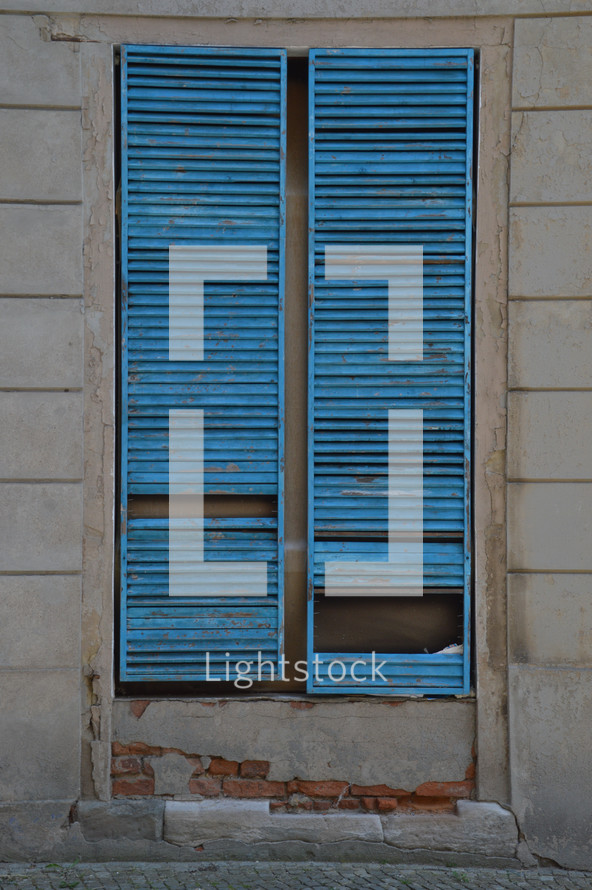 broken blue shutters in a window 