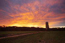 a silo on farmland at sunset 