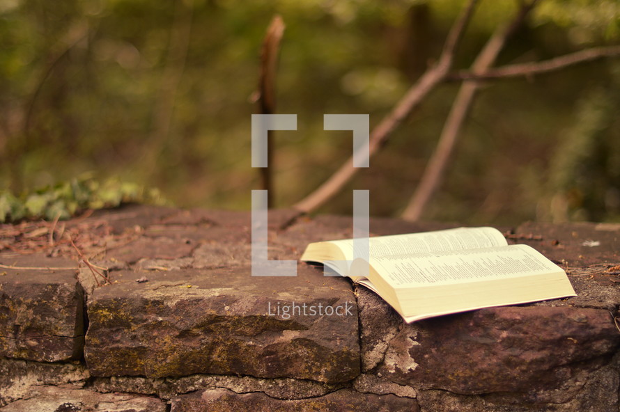 open Bible on the top of a stone wall 