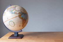 a globe on a wood desk 