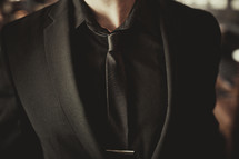 man's torso in a solid black suit