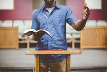 a man reading from a Bible during a worship service