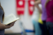 girl holding a Bible during a worship service 