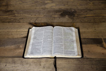 opened Bible on wood background 