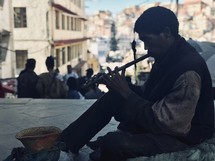 a man playing a flute on the street in Nepal 