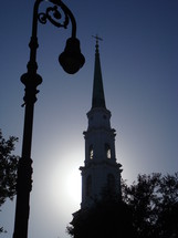 Silhouette of a light post and steeple 