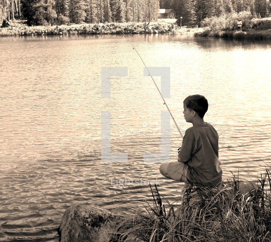 boy fishing on the shore of a lake