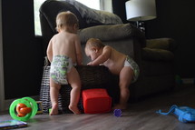 infants in diapers playing in a toy basket 