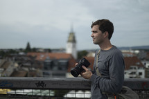 Man with camera in front of blurred city