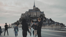 friends standing at a harbor with a castle in the background 