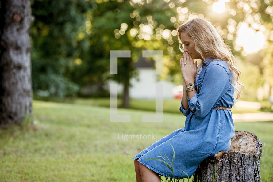 a woman outdoors praying 