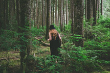 a woman walking in a forest alone 
