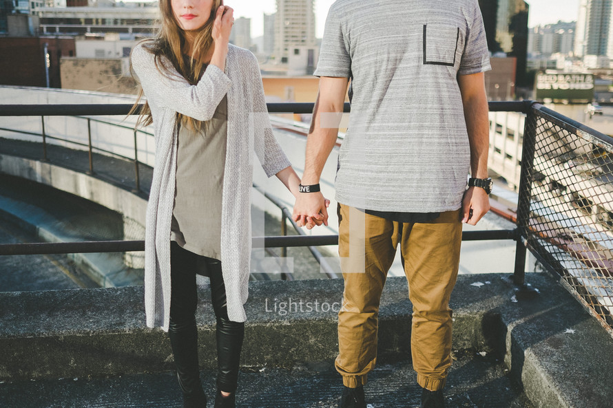 couple holding hands on a rooftop 
