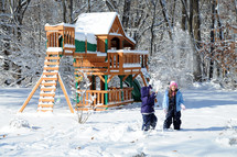 girls playing in the snow near a playground 