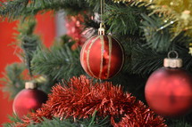 gold and red ornaments and tinsel on a Christmas tree