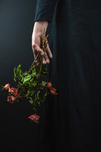 a woman with a bouquet of dead roses 