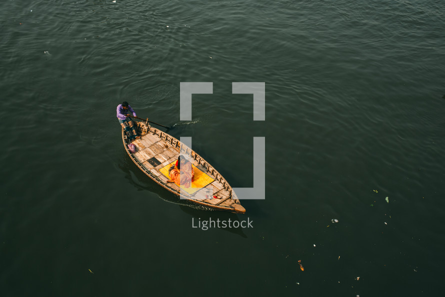 woman on boat crossing river in Dhaka, bangladesh