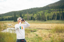 a man with binoculars outdoors 