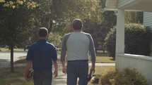 men walking carrying Bibles heading towards a Bible study 