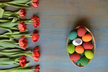 red tulips and an Easter basket full of Easter eggs 