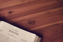BIble on a wood floor opened to Daniel 