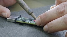 Manual soldering of electronic components on a PCB board, close up