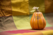 words GATHER HOPE on a pumpkin