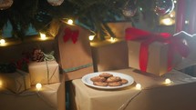 Santa Claus takes cookies under tree