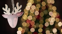 Reindeer decoration with Blurred Christmas tree in the background