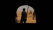 view of people walking in a desert through a window 