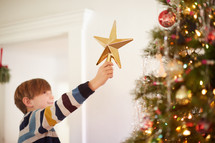 child decorating a Christmas tree