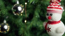 small snowman and balls decoration on a Christmas tree 