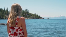 a woman standing on the shore looking out at Lake Tahoe
