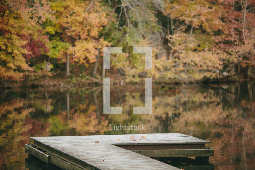 Empty dock with Fall colors over a lake